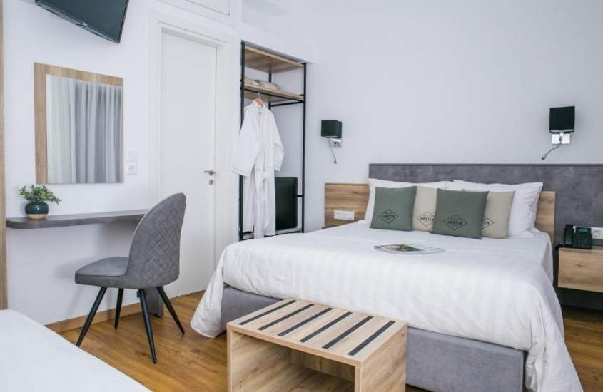 cama de casal, mesa, cadeira e televisão em suíte de Acropolis Vision, um dos melhores hotéis em atenas