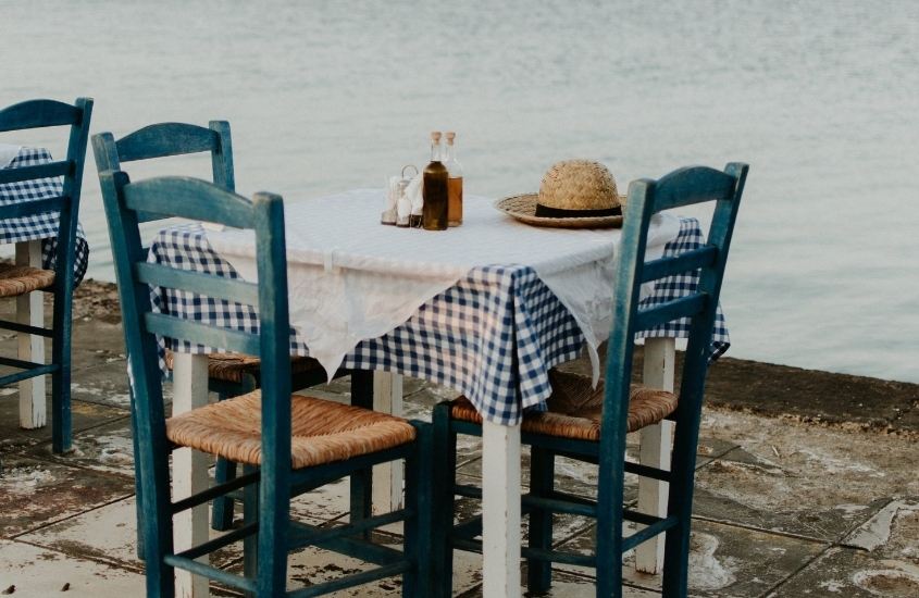 mesa e cadeiras de restaurante em frente ao mar, durante o dia