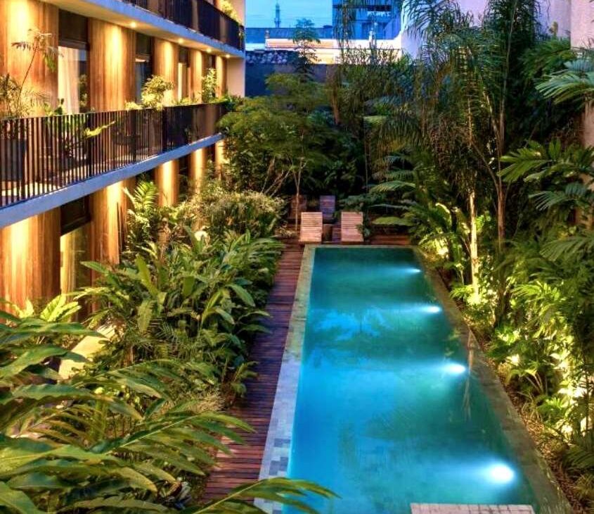 Piscina cercada de plantas em área de lazer de Hotel Villa Amazônia, um dos hotéis em Manaus com banheira