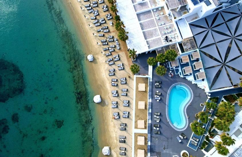 vista aérea de mar, areia e piscina em cobertura de prédio, durante o dia em mykonos