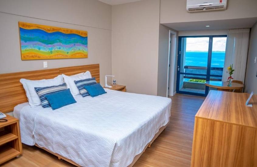 cama de casal e varanda com vista para o mar em suíte de Grande Hotel da Barra