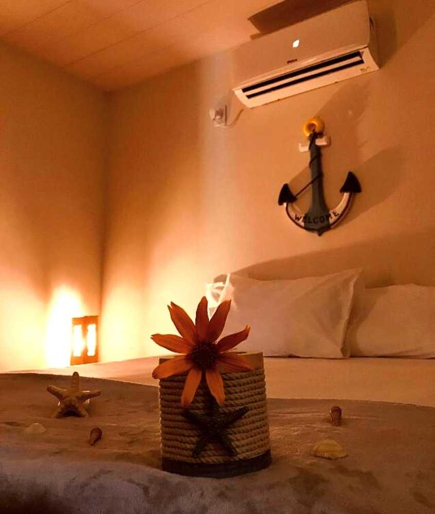 pote decorado com estrela do mar e flores em cima de cama de casal em suíte de Martinelli Residence
