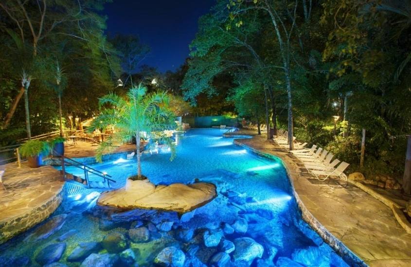 piscina cercada de árvores, durante a noite em área de lazer de rio quente resorts
