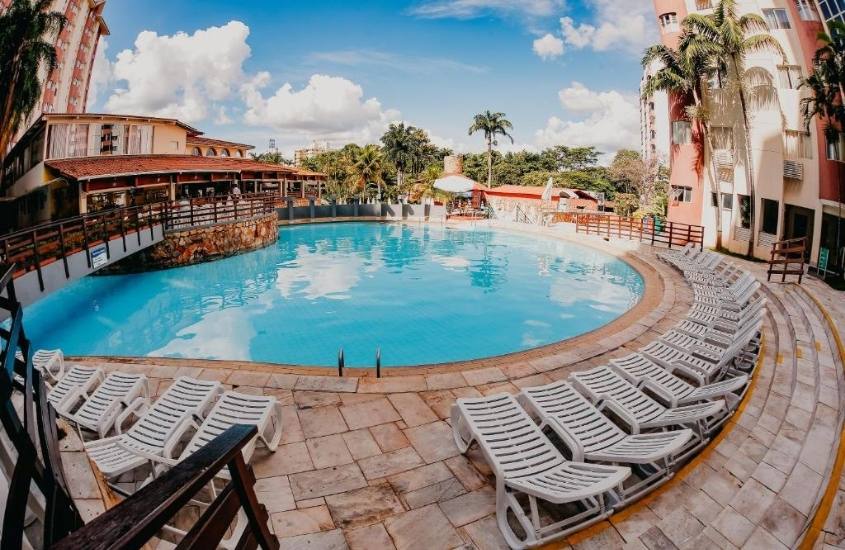 espreguiçadeiras em frente a piscina, durante o dia em área de lazer de hot springs, um dos melhores hoteis em caldas novas