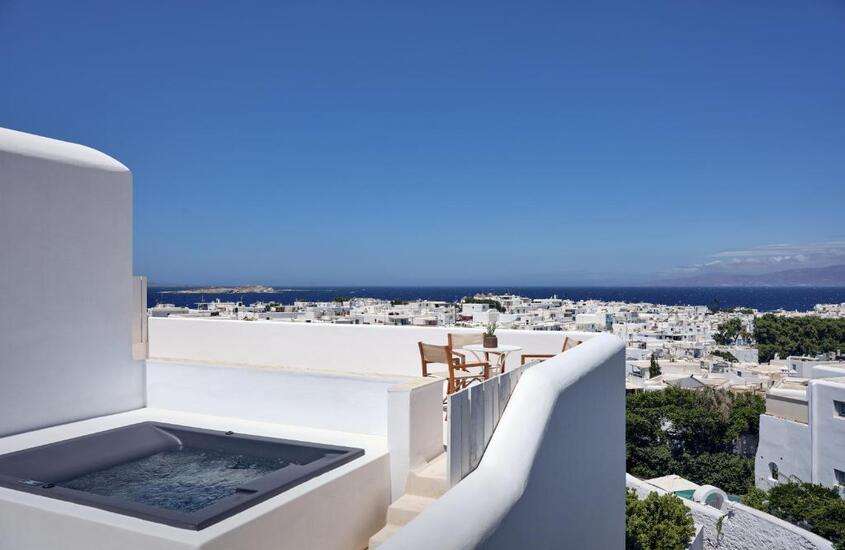 durante dia ensolarado, hidromassagem em varanda de suíte de hotel em mykonos com vista para o mar
