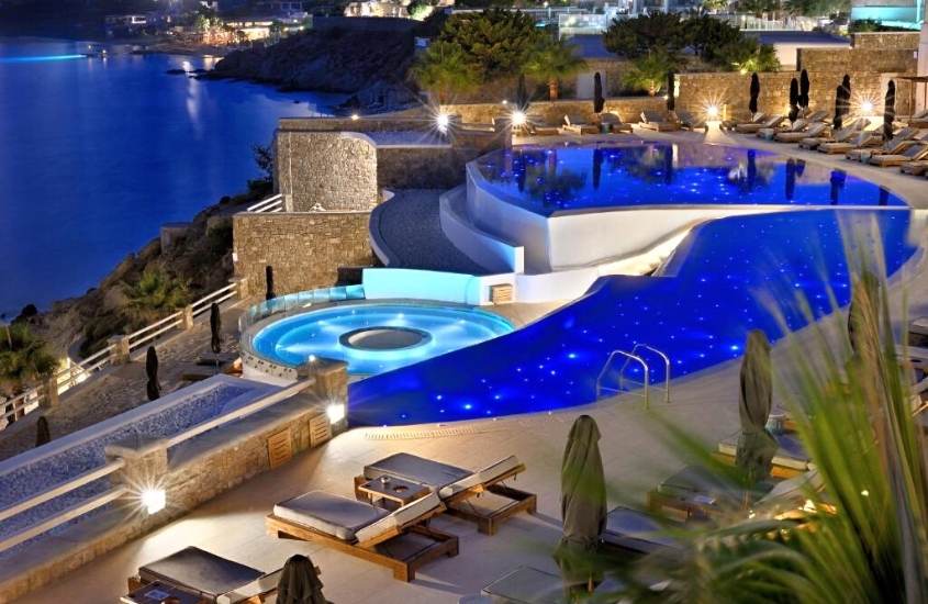 durante a noite, vista aérea de área de lazer de Anax Resort and Spa, onde há piscinas e espreguiçadeiras com vista para o mar