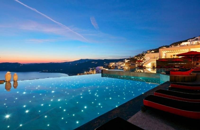 piscina de borda infinita com vista para o mar, durante entardecer em área de lazer de Myconian Avaton - Design Hotels, um dos melhores hotéis em mykonos