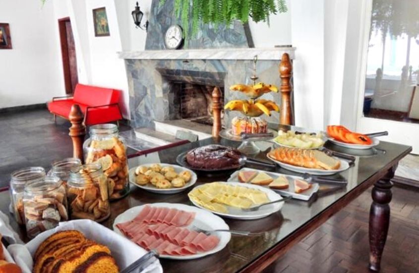 presuntos, queijos, bolos e frutas em cima de mesa de café da manhã de Hotel Pieta