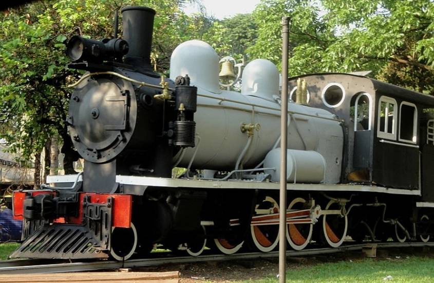 durante o dia, locomotiva preta, branca e vermelha para em estação ferroviária, uma atração para quem vai fazer turismo em garibaldi