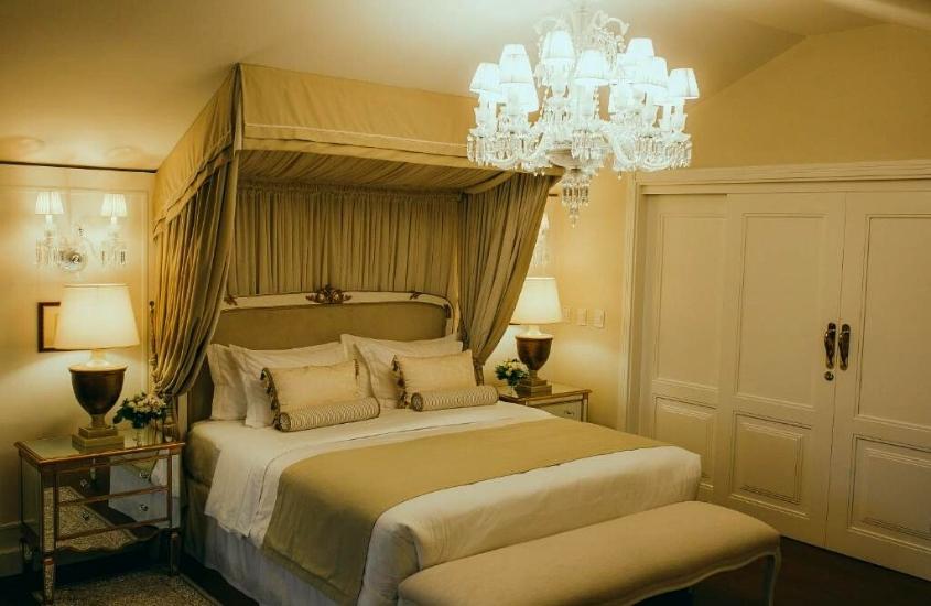 travesseiros em cima de cama de casal e abajur em cima de mesas de cabeceiras em suíte de Villa do Vale Boutique Hotel