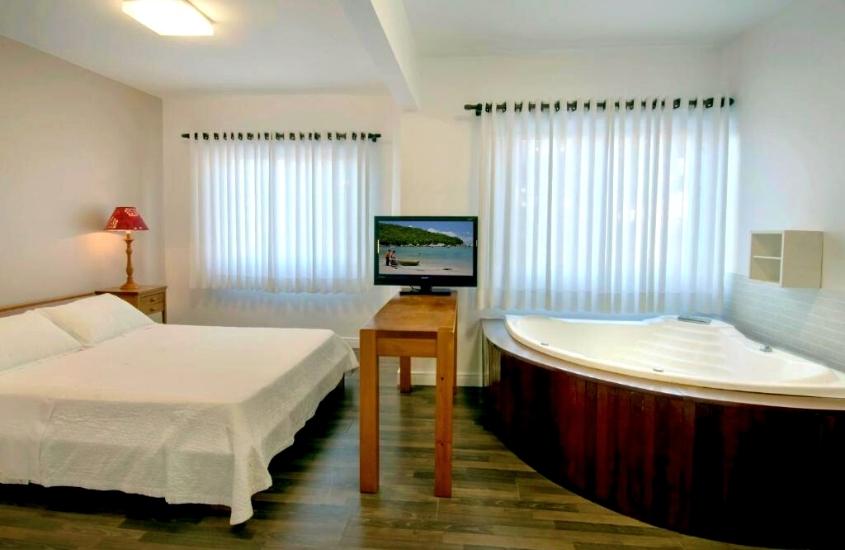 cama de casal e banheira de hidromassagem em quarto de Pousada Bora Bora em Bombinhas