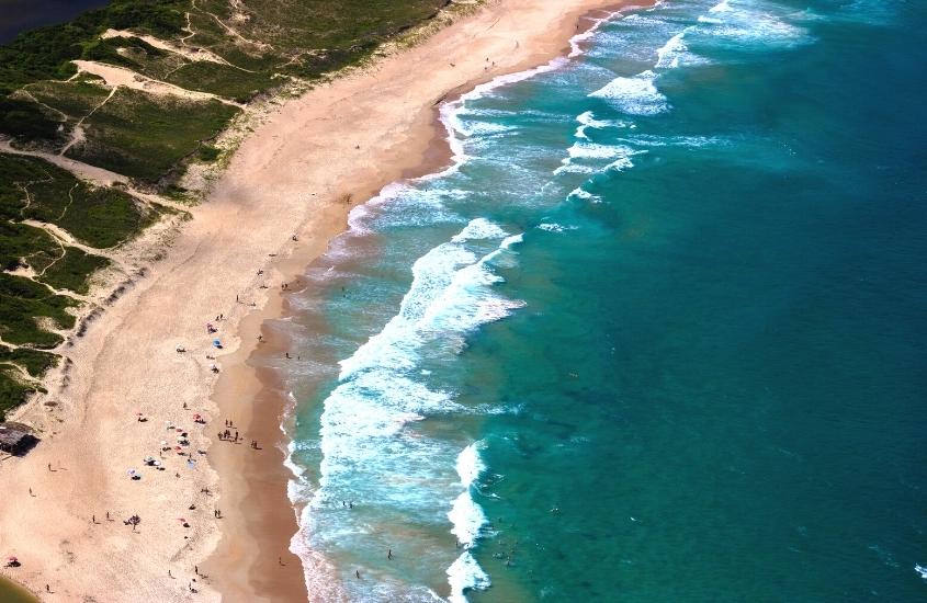 vista aérea de pessoas na areia e mar em praia de florianópolis, durante o dia