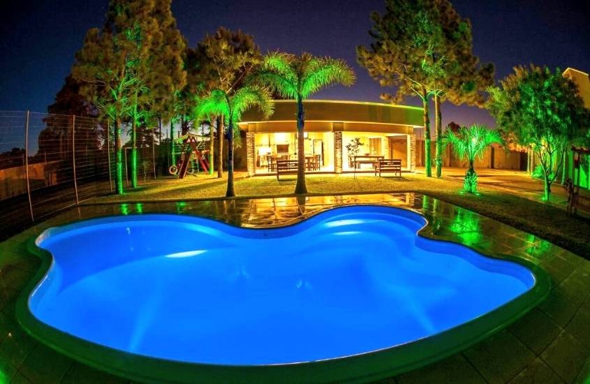 durante a noite, piscina cercada por árvores, em área de lazer iluminada de Província Casa Hotel