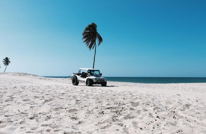 buggy branco estacionado em areia de praia, durante o dia
