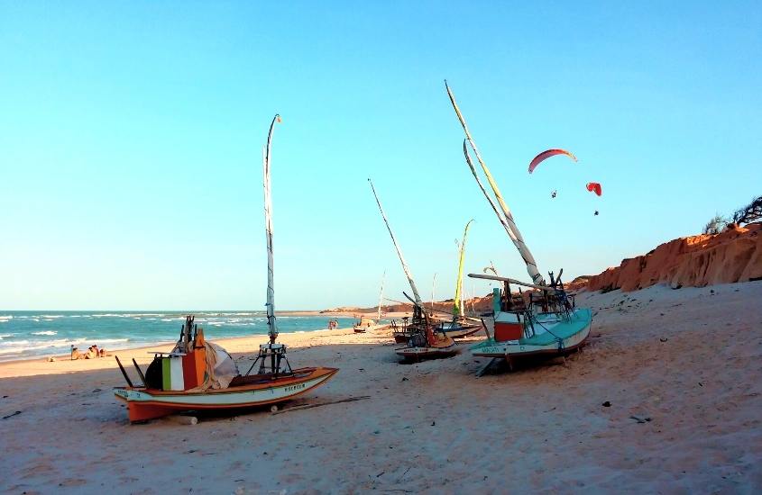 durante o dia, barcos atracados em areia de praia, uma opção para quem busca o que fazer em canoa quebrada em 1 dia