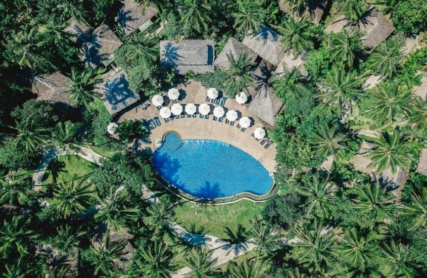 vista aérea de piscina cercada por coqueiros em área de Ban Sainai Resort