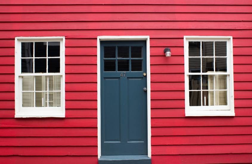 casa vermelha com janelas brancas e porta azul