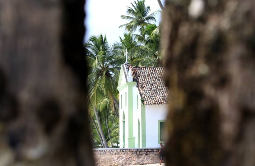 igreja cercada de coqueiros, durante o dia em praia dos carneiros