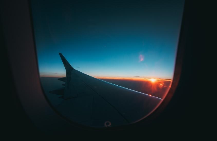 pôr do sol visto de janela de avião no céu