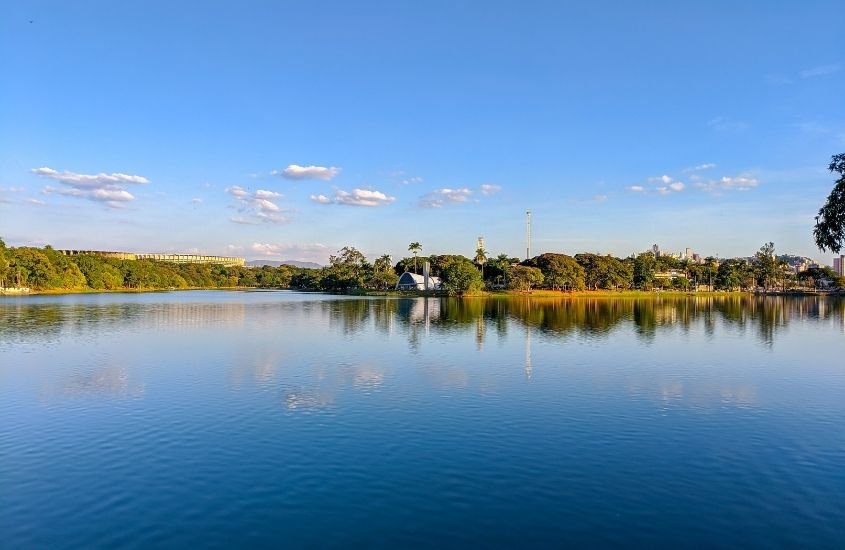 vista panorâmica de lago rodeado por árvores, durante o dia em belo horizonte, principal destino em um Roteiro Minas Gerais