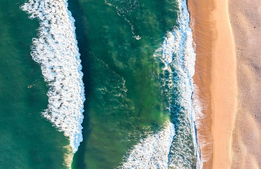 durante o dia, vista aérea de areia e mar