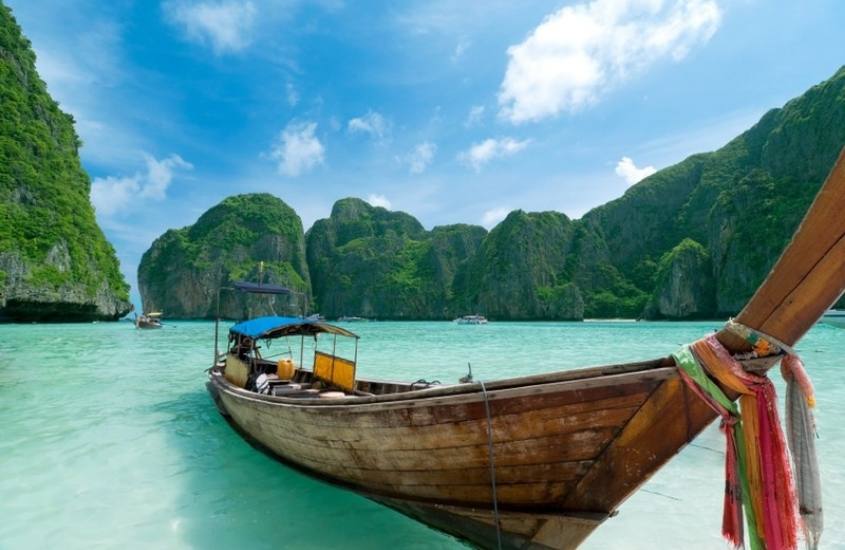 durante o dia, barco de madeira em mar azul de ilha de phuket