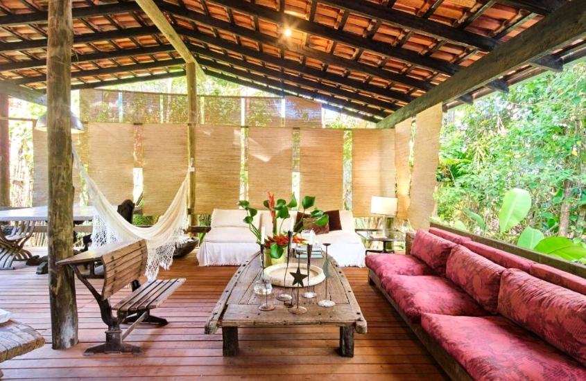 rede de descanso, mesas, banco de madeira e sofá em lounge de Residence Picinguaba, lugar para quem busca onde ficar em ubatuba