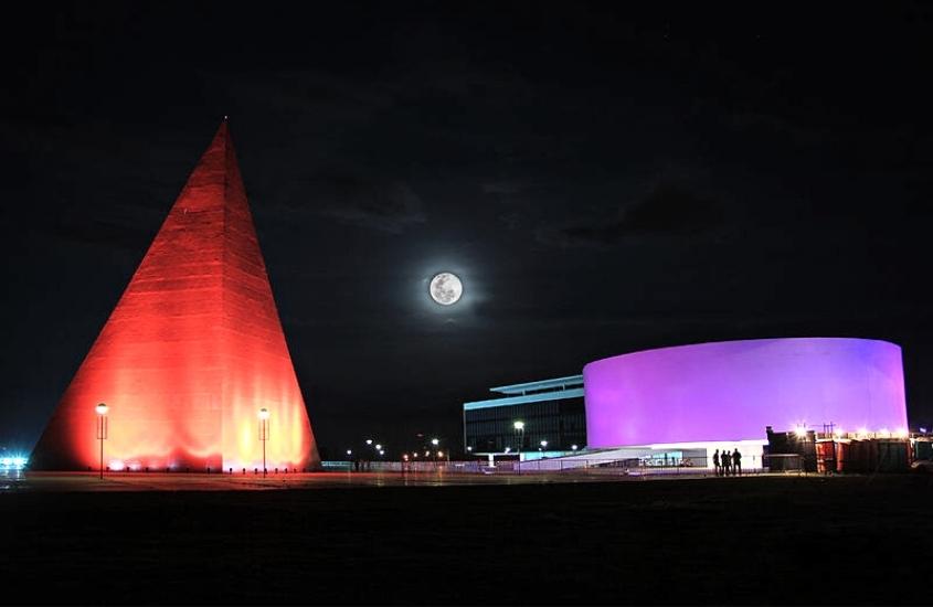 pirâmide iluminada por luz vermelha, durante a noite em centro cultural oscar niemeyer, atração para quem busca o que fazer em goiás