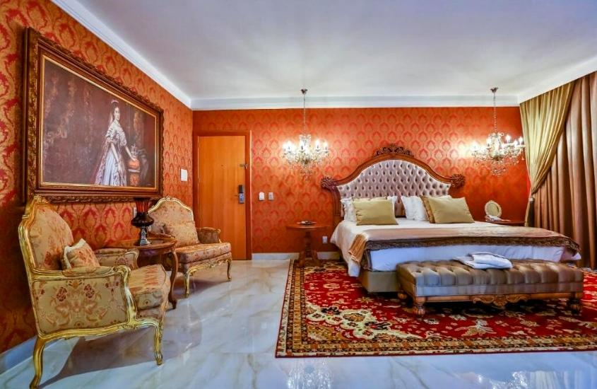 poltronas e frente a cama de casal em suíte decorada em estilo imperial de Golden Lis Hotel Boutique