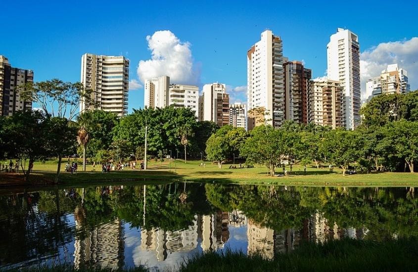 lago cercado de árvores e prédios ao fundo, durante o dia em goiânia, um dos lugares em Goiás para viajar