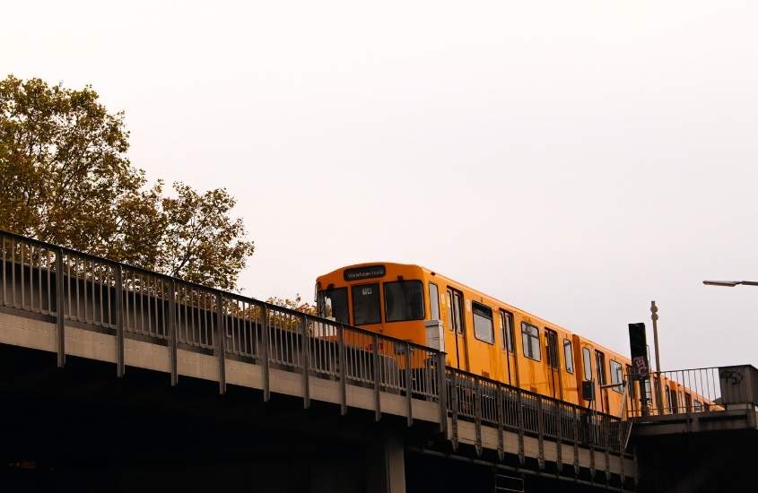 trem amarelo passando em trilho, durante dia nublado na alemanha