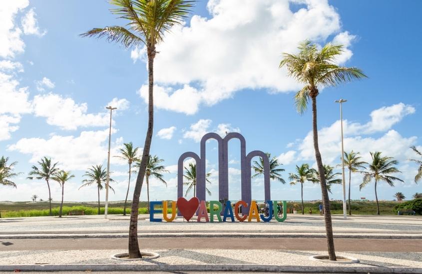 durante o dia, letreiro colorido escrito ''eu amo aracaju'', rodeado de coqueiros em orla de atalaia, um dos melhores pontos turísticos de aracaju