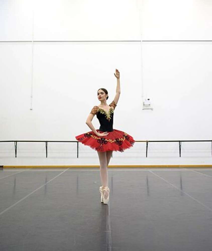 bailarina com collant, saia vermelha e sapatilha branca, dança em salão de escola do teatro bolshoi