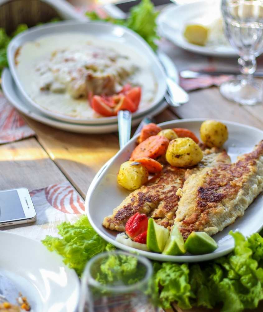 Prato com peixe e salada servido a mesa
