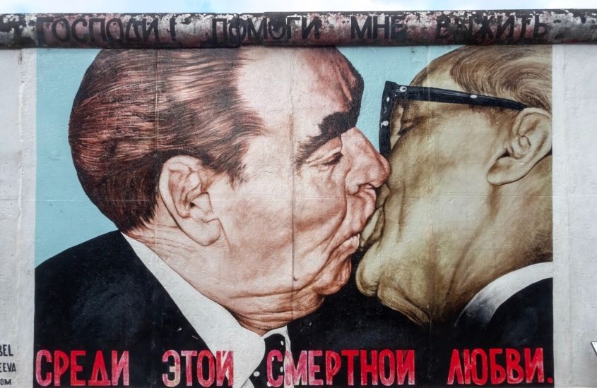durante o dia, pintura de políticos se beijando, em restos de muro de berlim, um dos pontos turísticos da alemanha
