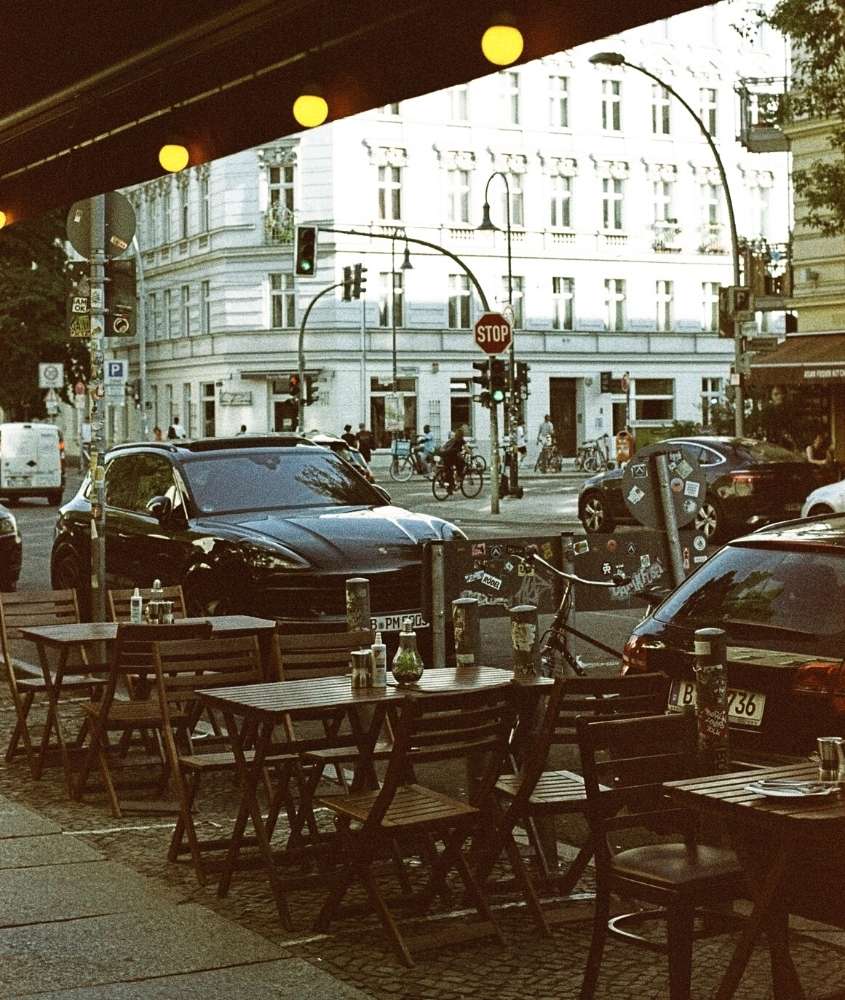 durante o dia, mesas e cadeiras em calçada de Prenzlauer Berg, bairro onde ficar em berlim alemanha