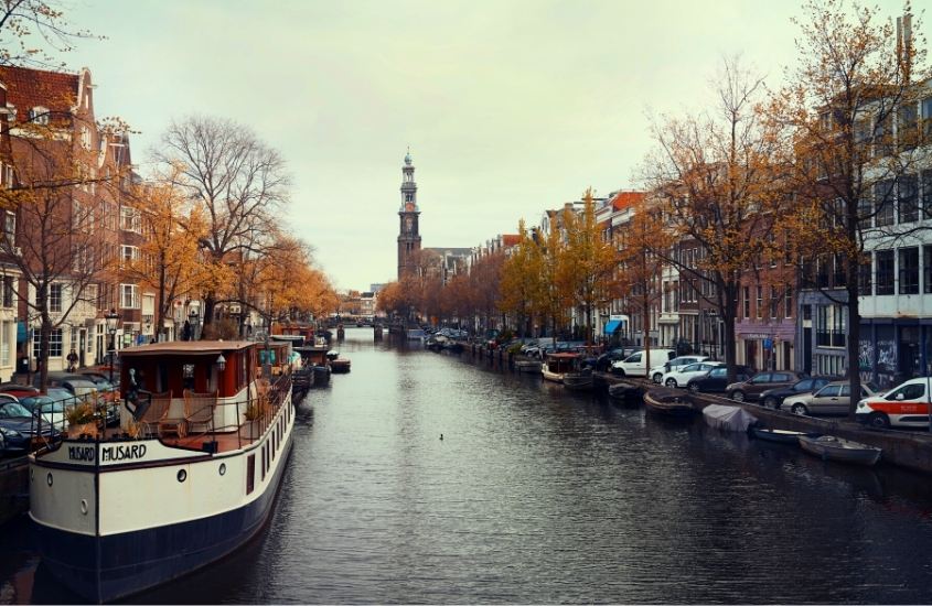 durante o dia, barcos em canal de bairro jordaan, atração para quem busca o que fazer em Amsterdam