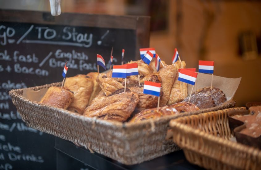bandeirinhas da holanda em cima de doces típicos, expostos para venda em um dos restaurantes em amsterdam