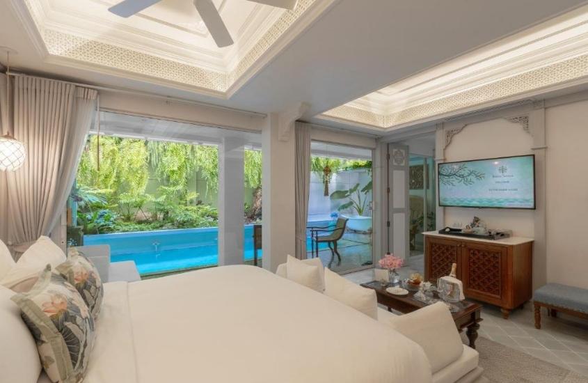 durante o dia, cama de casal em suíte com ampla janela com vista para varanda onde há piscina privativa