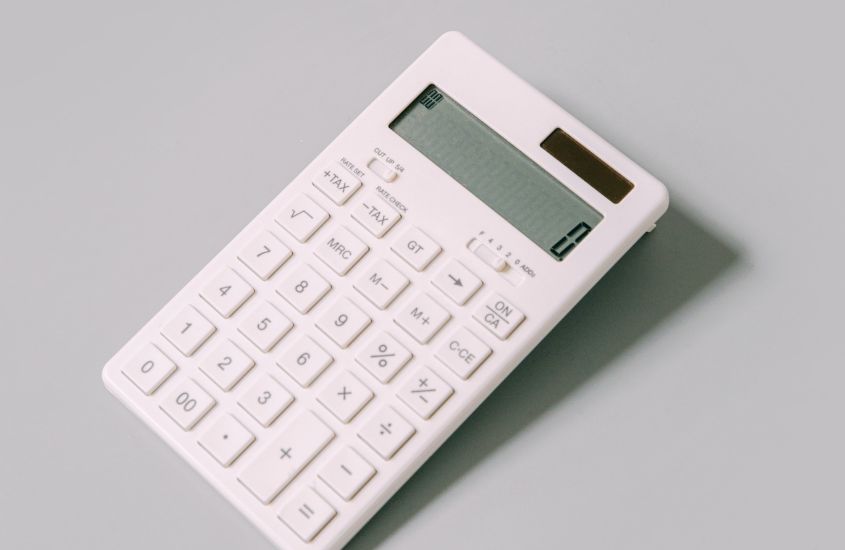 calculadora branca mostrando número zero, em cima de mesa branca para calcular valor de roteiro bucareste