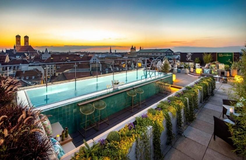 durante entardecer, piscina em cobertura com vista para a cidade em um dos hotéis em munique próximo a marienplatz