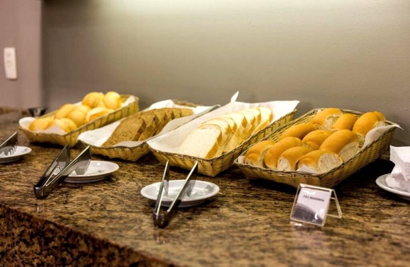 diversos pães em cima de mesa de refeitório de um dos melhores hoteis em porto alegre