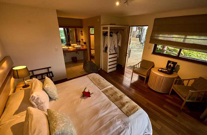 cama de casal, poltronas e guarda-roupa em suíte de hotel em ilha de páscoa, destino de viagem para o chile