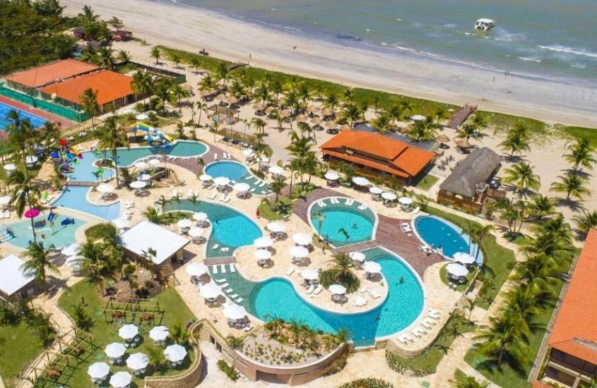 durante o dia, vista aérea de diversas piscinas em área de lazer de um dos resorts all inclusive mais baratos do Brasil, ao fundo, mar
