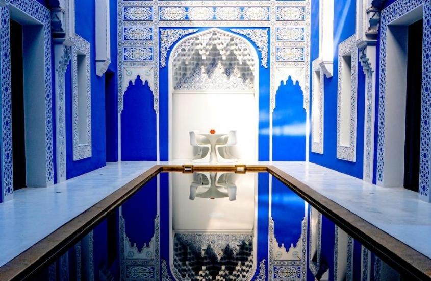 piscina em pátio com paredes azuis e detalhes brancos de um dos melhores riads em marrakech