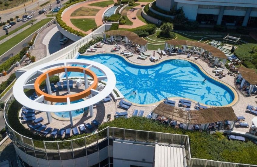 durante o dia, vista aérea de espreguiçadeiras ao redor de piscina em cobertura de um dos hotéis em punta del este