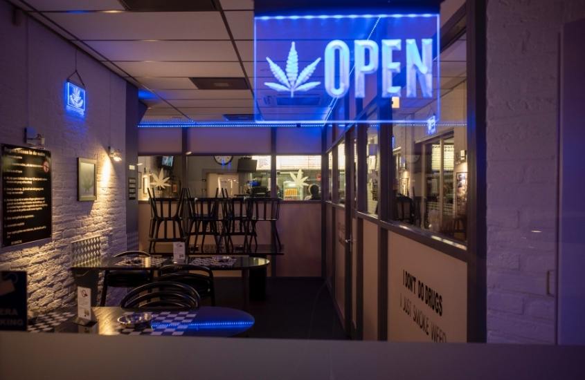 placa azul, escrito 'open' com símbolo de planta cannabis, legalizada na cultura do canadá