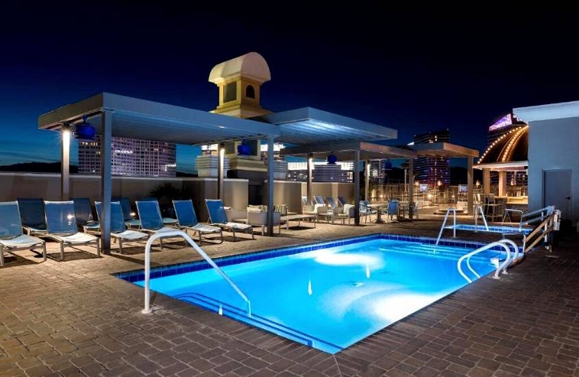 durante a noite, espreguiçadeiras ao redor de piscina em um dos hotéis em Las vegas que não cobram taxa de resort