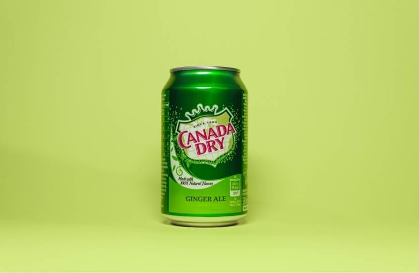 lata verde de refrigerante ginger ale, uma das bebidas típicas do Canadá, em fundo verde