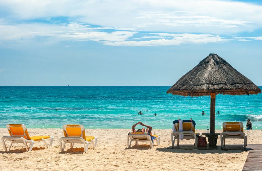 durante o dia, cadeiras de praia em frente a mar de uma das praias em cancún
